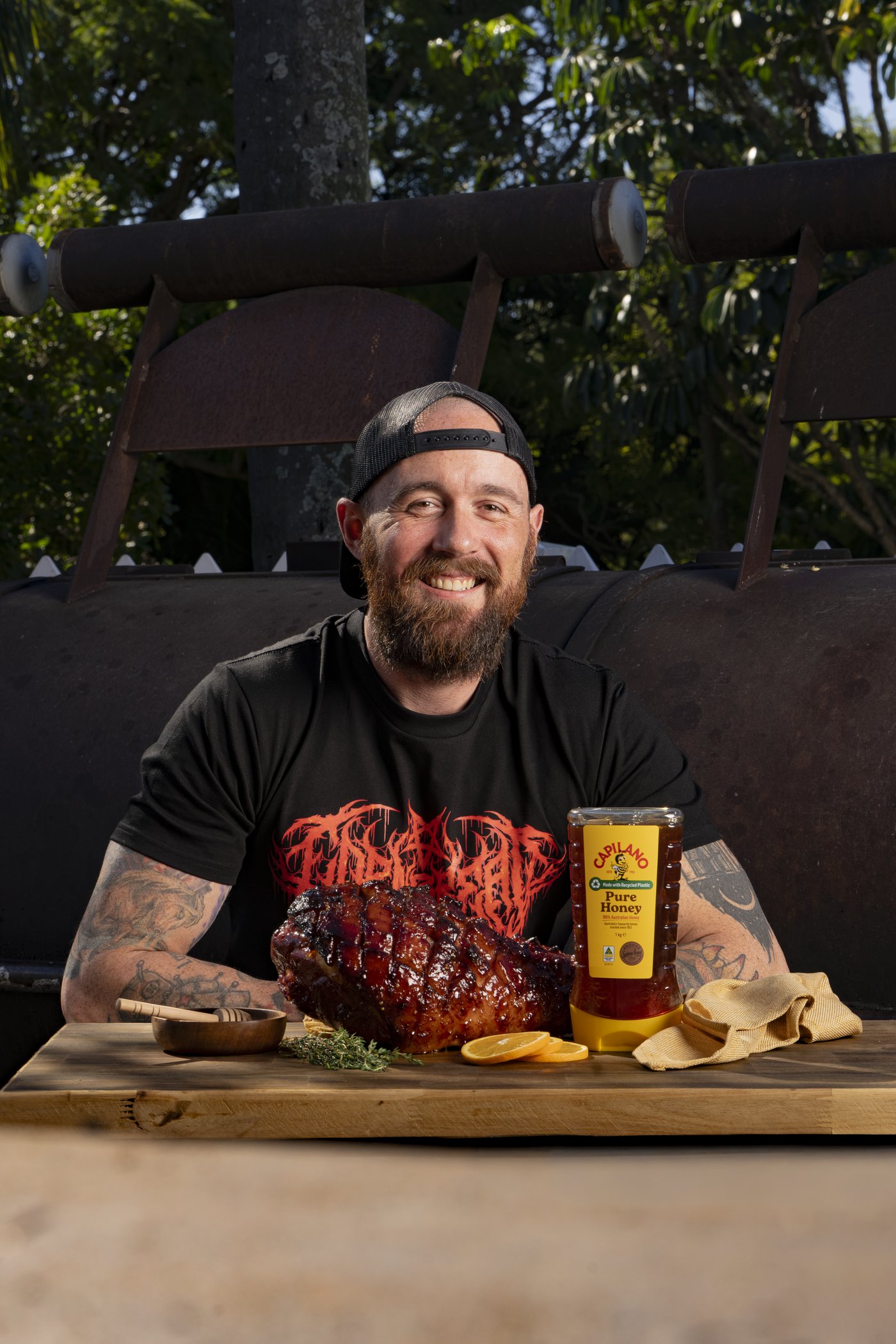 Sam Herbert with a glazed ham at his smoker